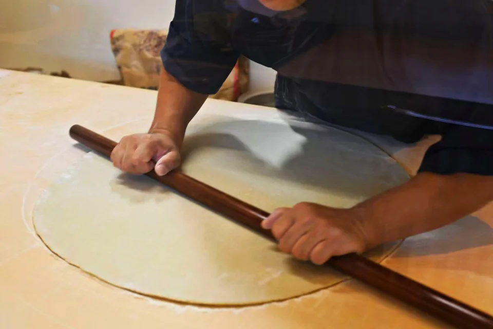 麺棒で、蕎麦の生地をのばす職人